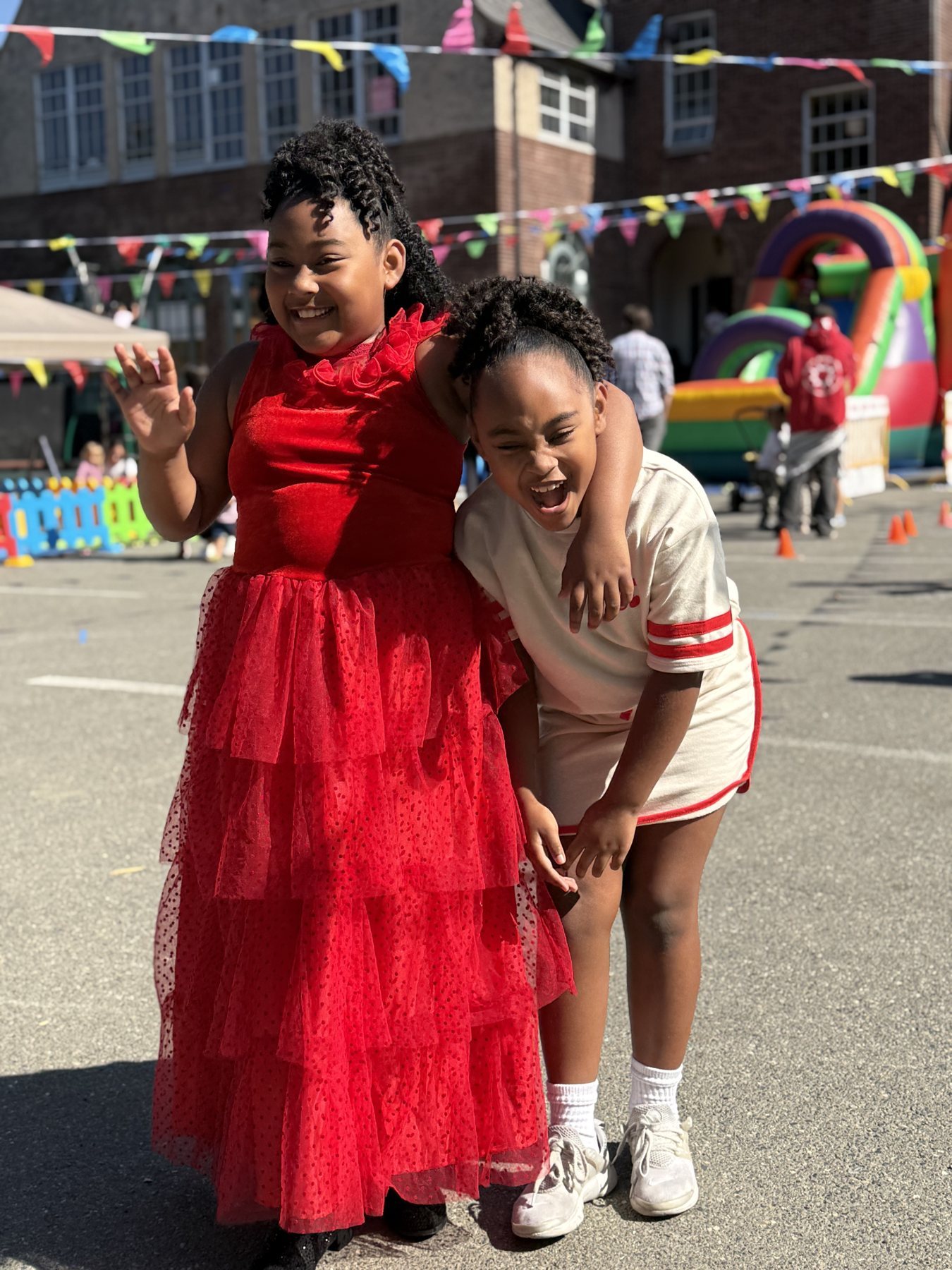 Two Amistad students laughing together at a school community festival