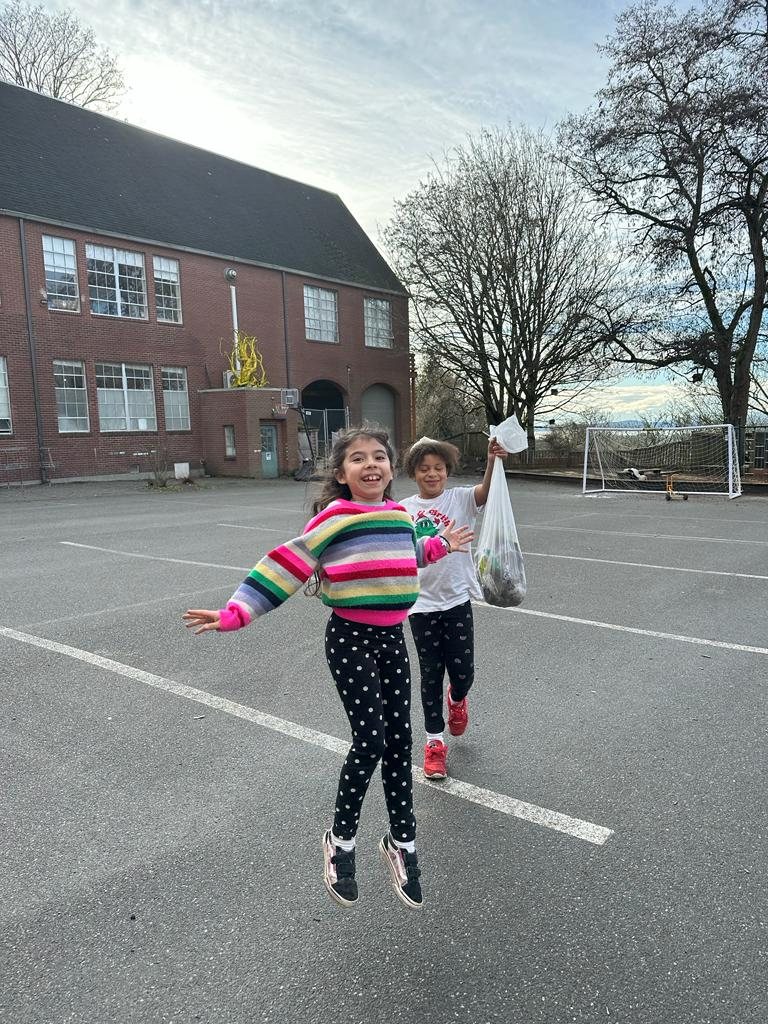 Two students jumping and smiling on the Amistad playground